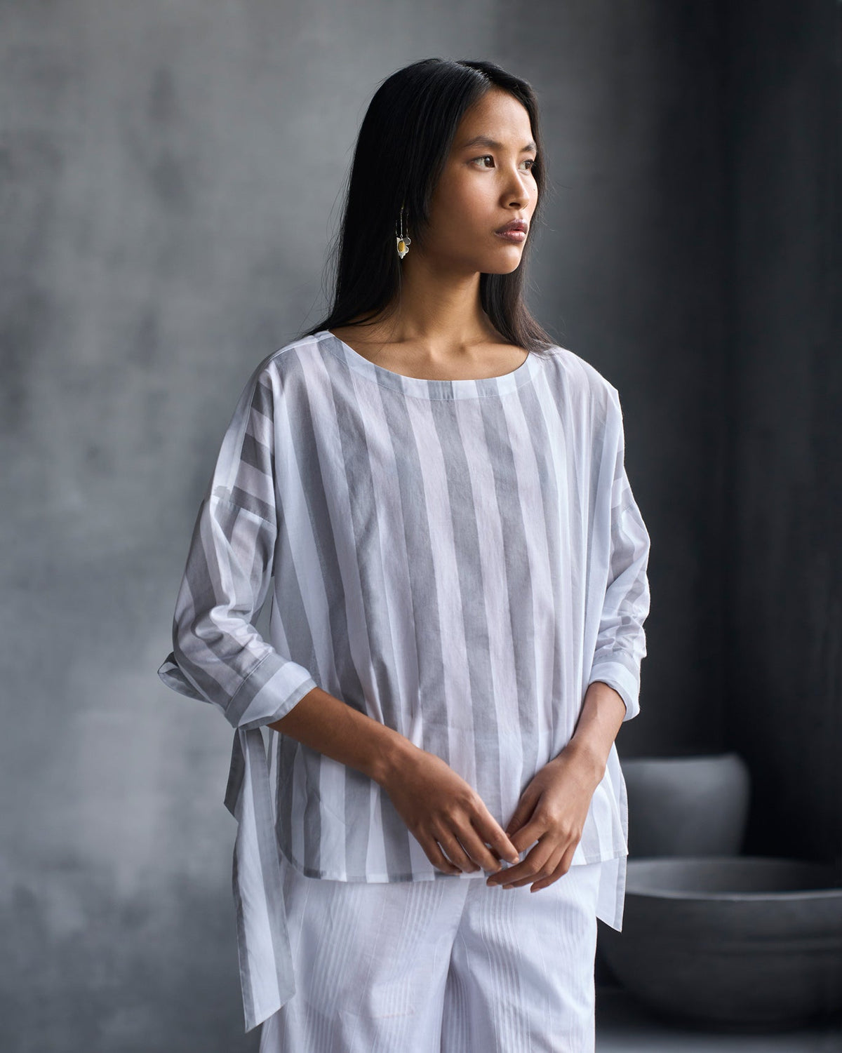 Person wearing the Back Fagotting Top in white and grey stripes.