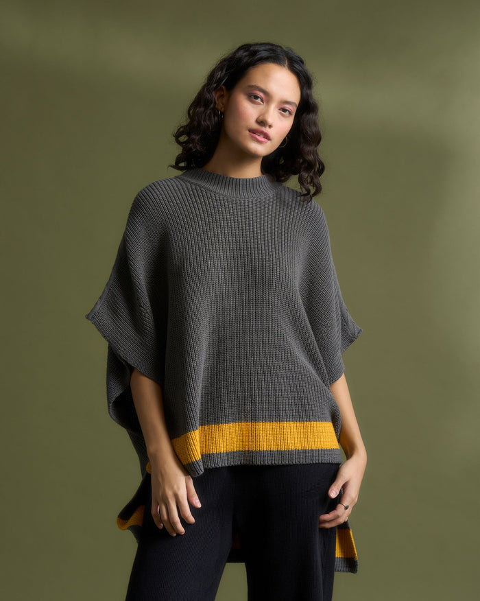 Person wearing the Dream High Low Hem Sweater in grey with a mustard hem band.