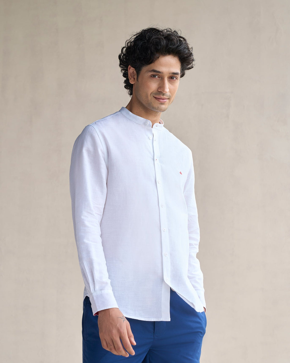 Person wearing a white Nawab shirt with a small red logo on the chest.