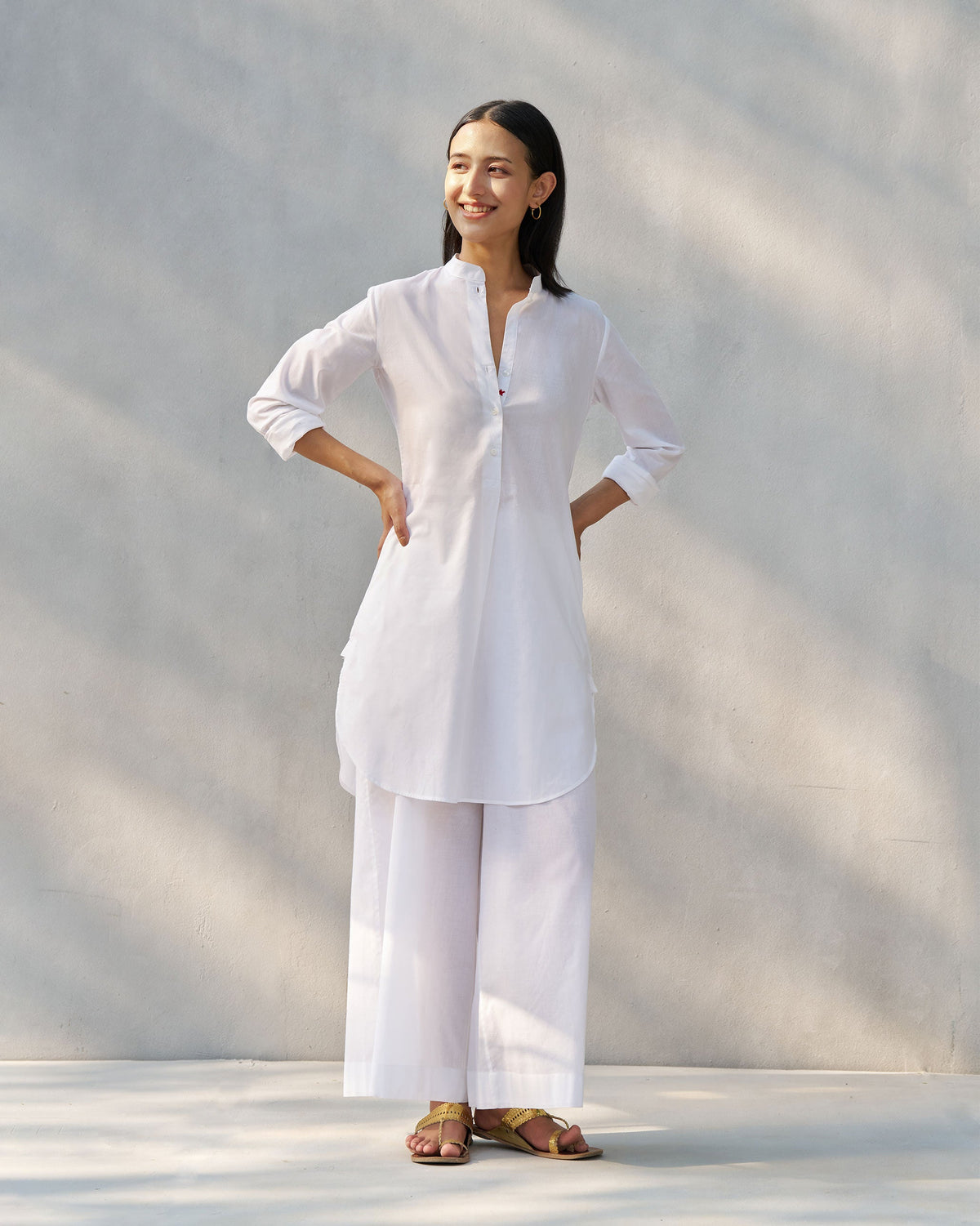 Person wearing a white Moon set with a mandarin collar tunic and wide pants.