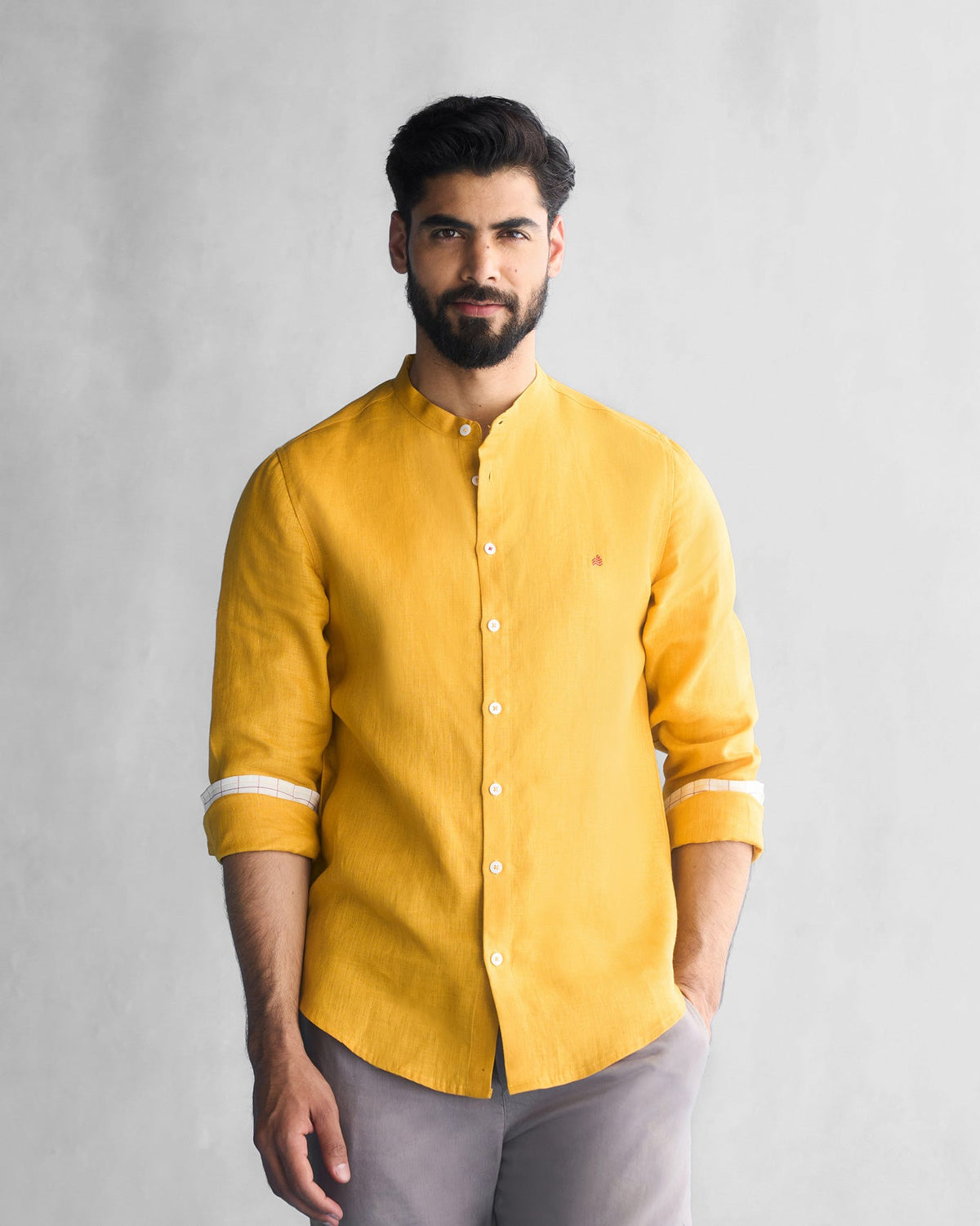 Person wearing an ochre Nawab shirt with striped cuff linings.