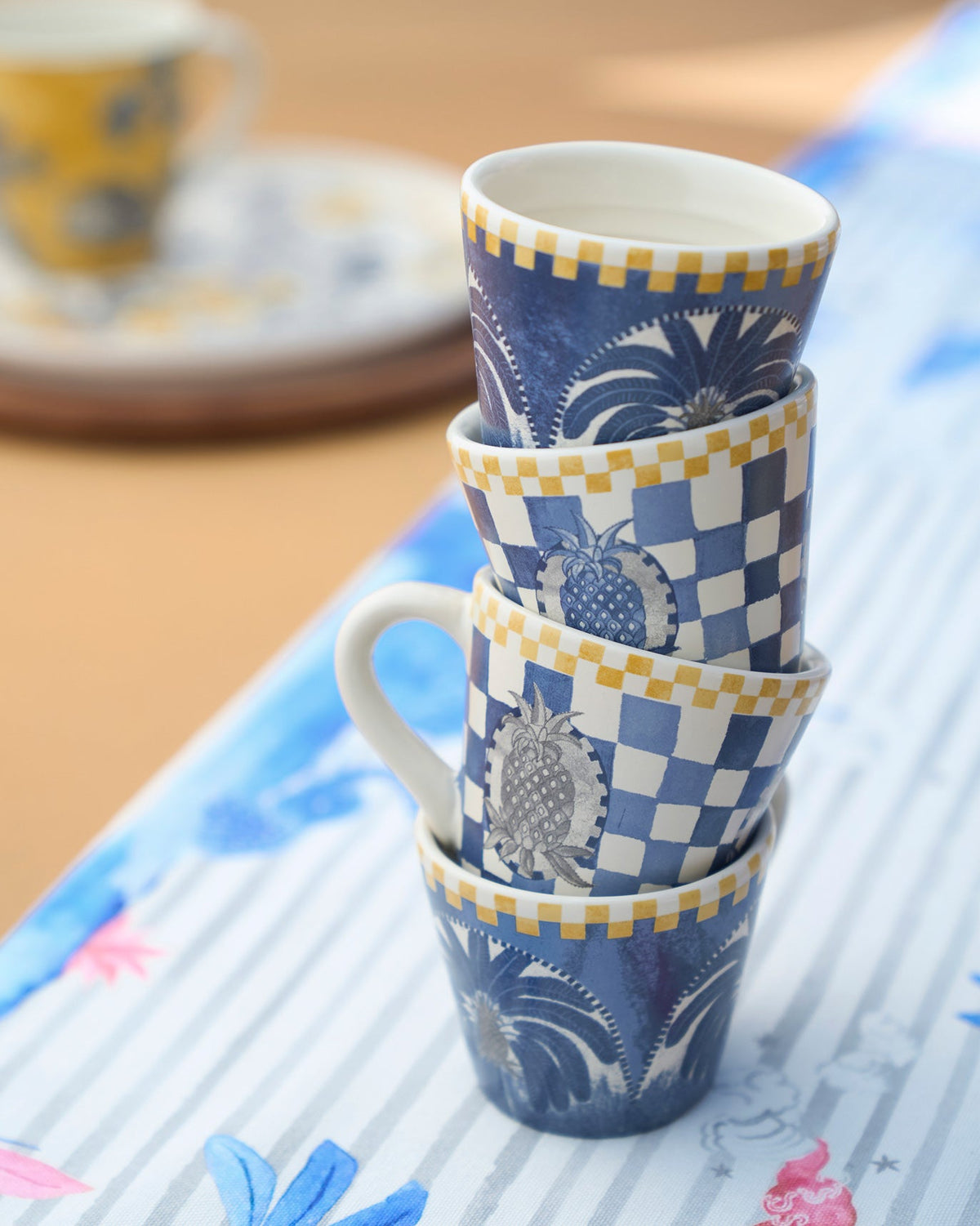 Bodhi Espresso Mugs stacked in a tower, showing checks and pineapple motifs.