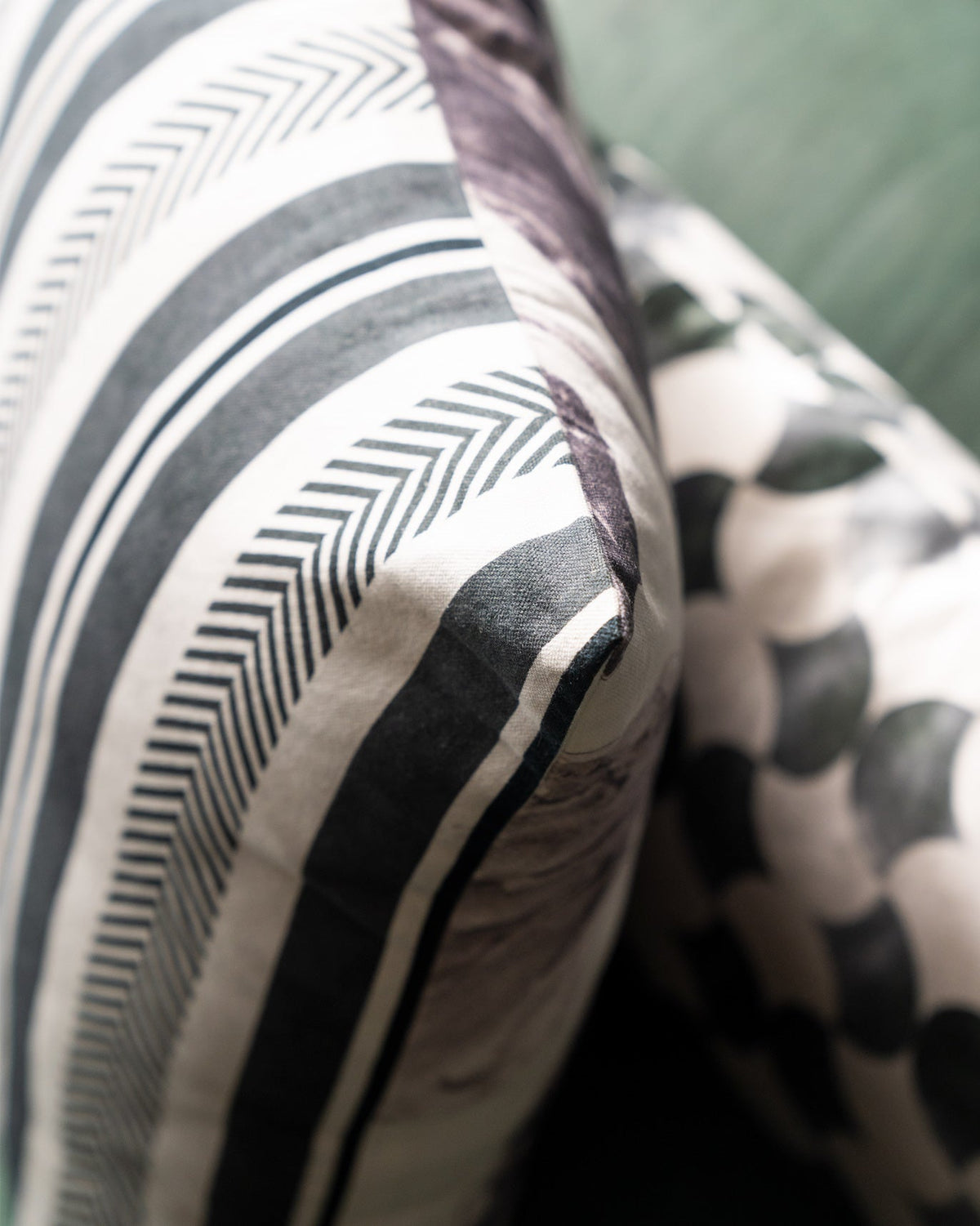 Close-up of a Lotus Euro Sham beside a striped cushion.