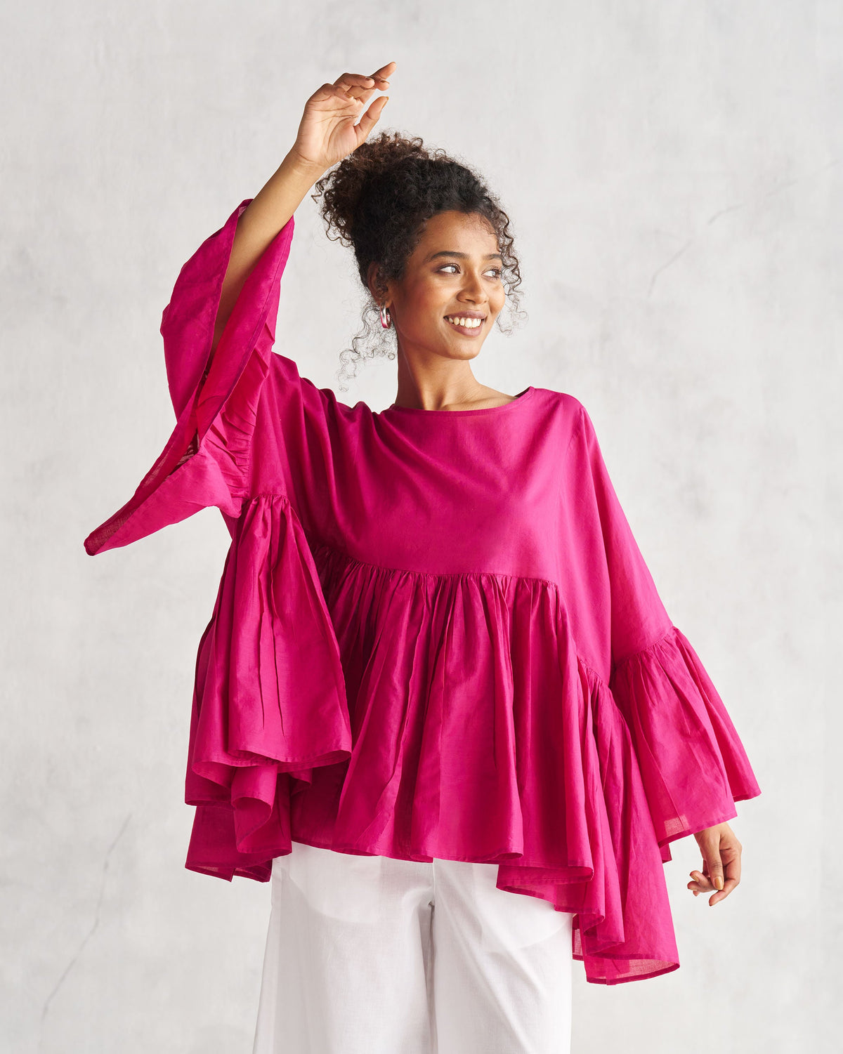 Side view of a berry Frill Top with one arm raised.