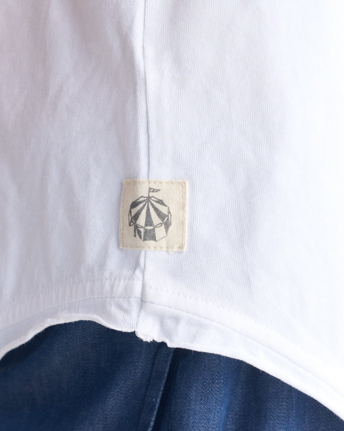 Close-up of a side-seam label on a white Ukiyo racerback tank.