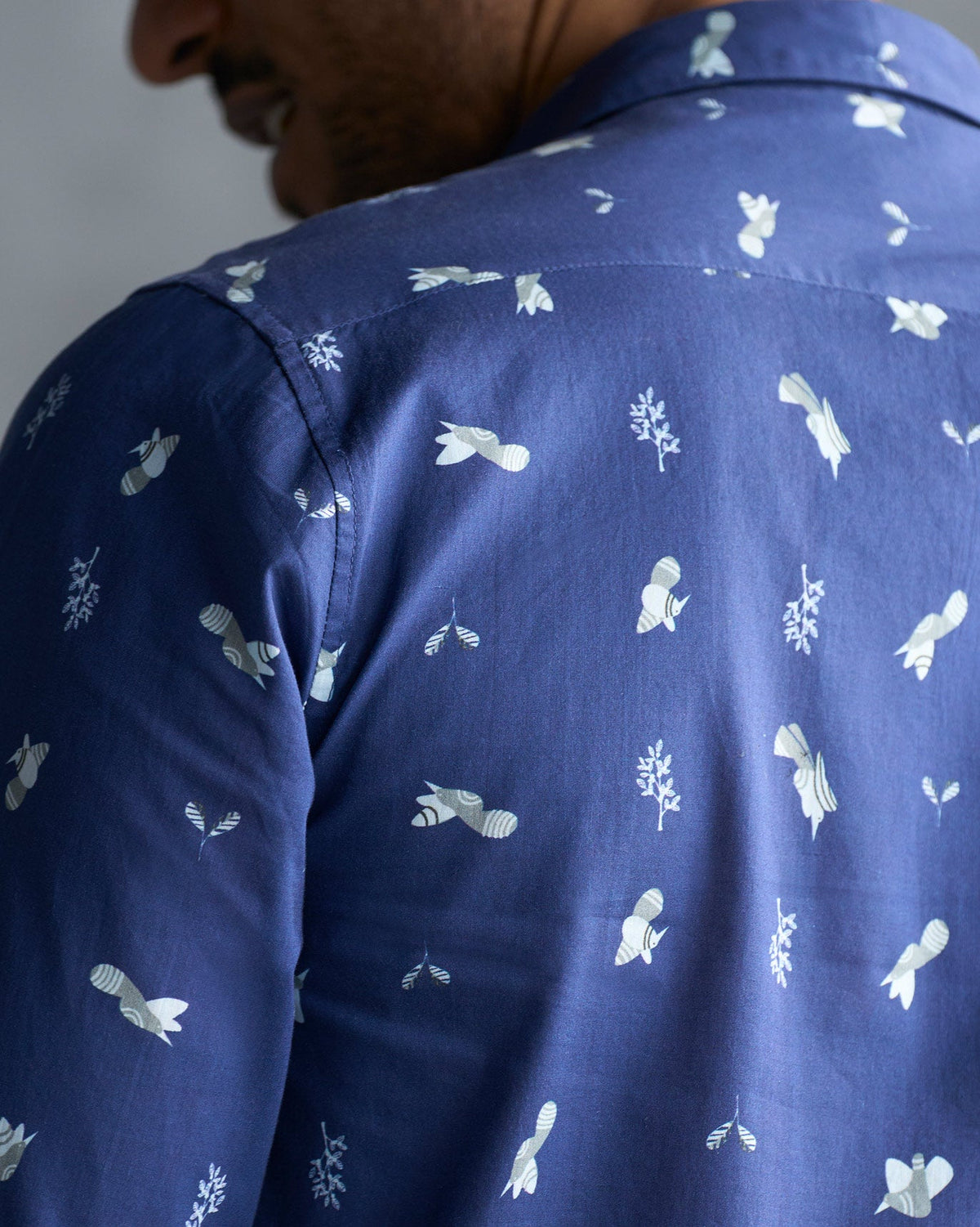 Close-up of the back of a navy Hakuna Shirt showing its small white print.