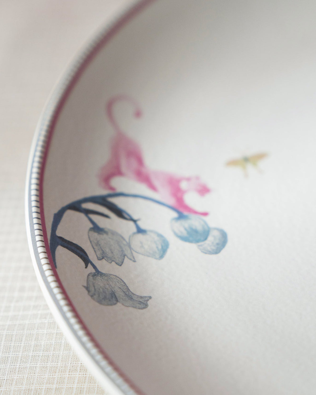 Close-up of a Myra dinner plate showing a pink tiger and blue flowers.