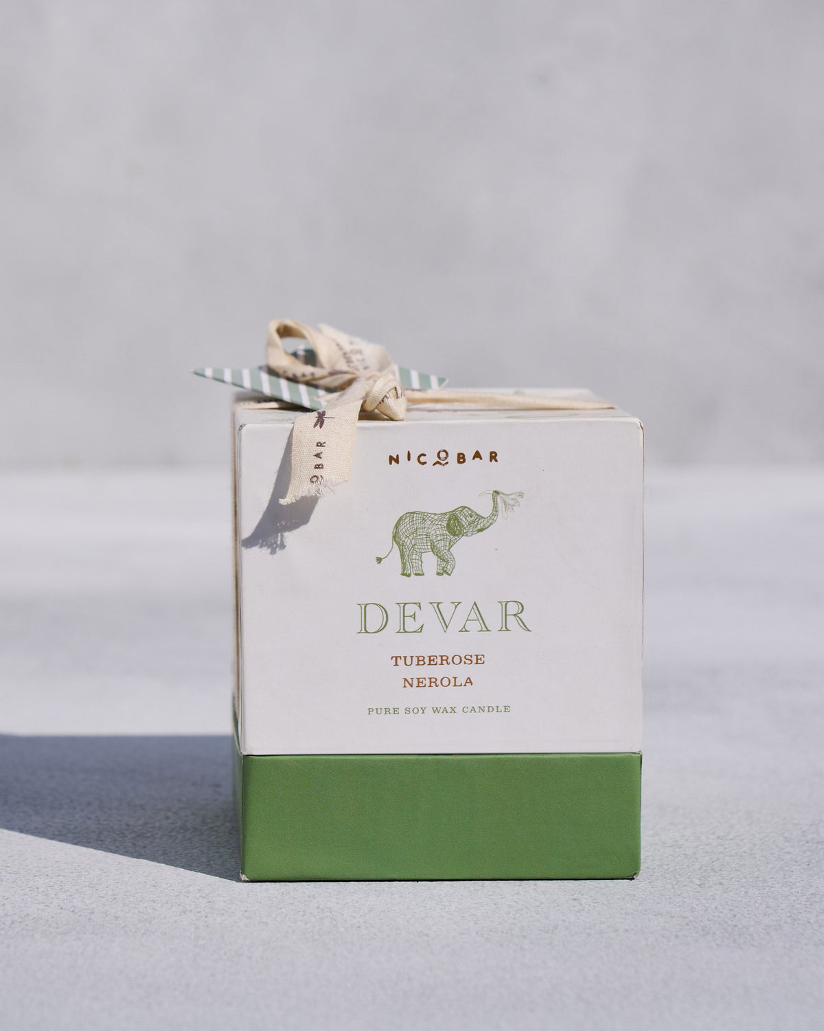 Devar candle gift box tied with a cream ribbon.