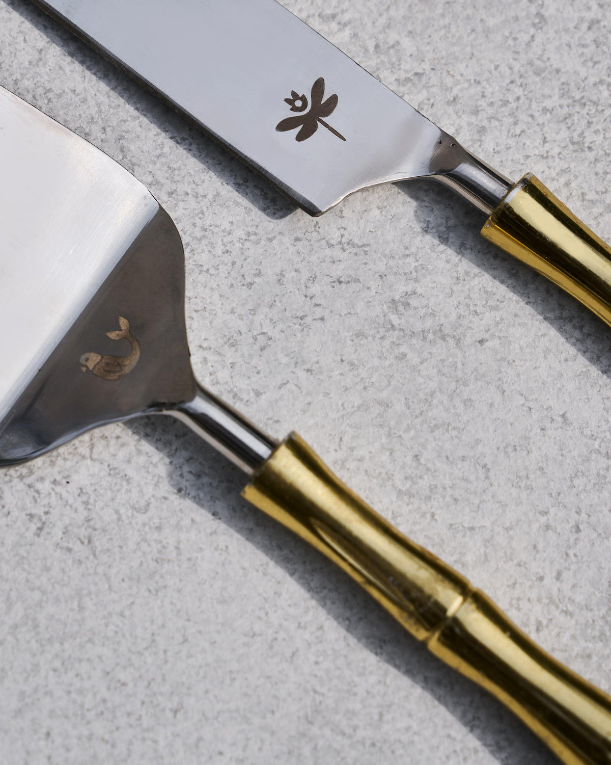 Sunrise cake knife with a dragonfly and server with a fish motif.