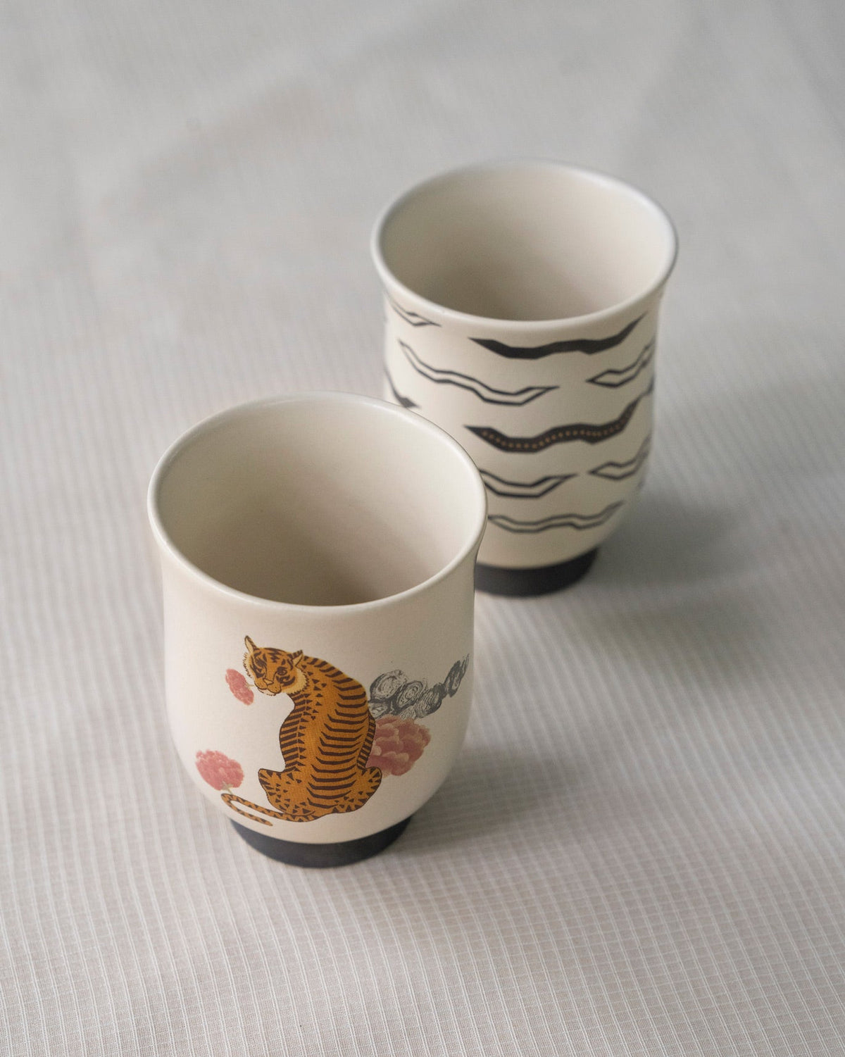 Sitara tea cups seen from above, with a tiger and black waves.