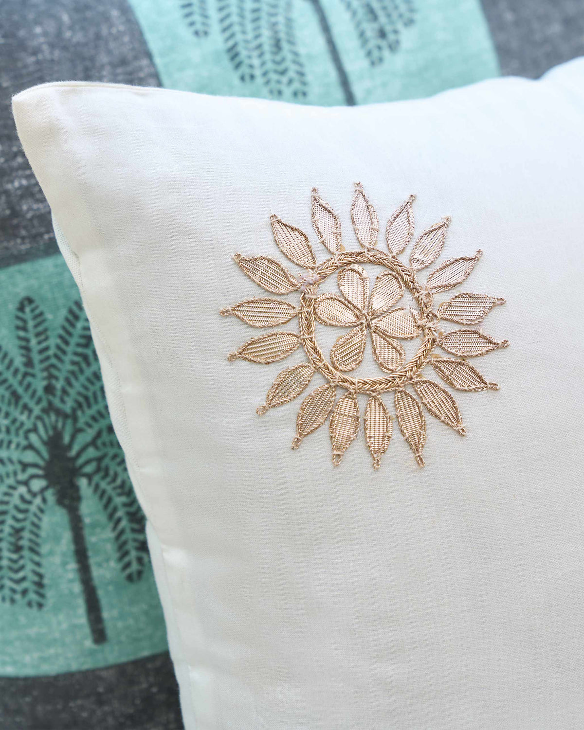 Close-up of a Chakra Cushion Cover showing a gold embroidered motif.