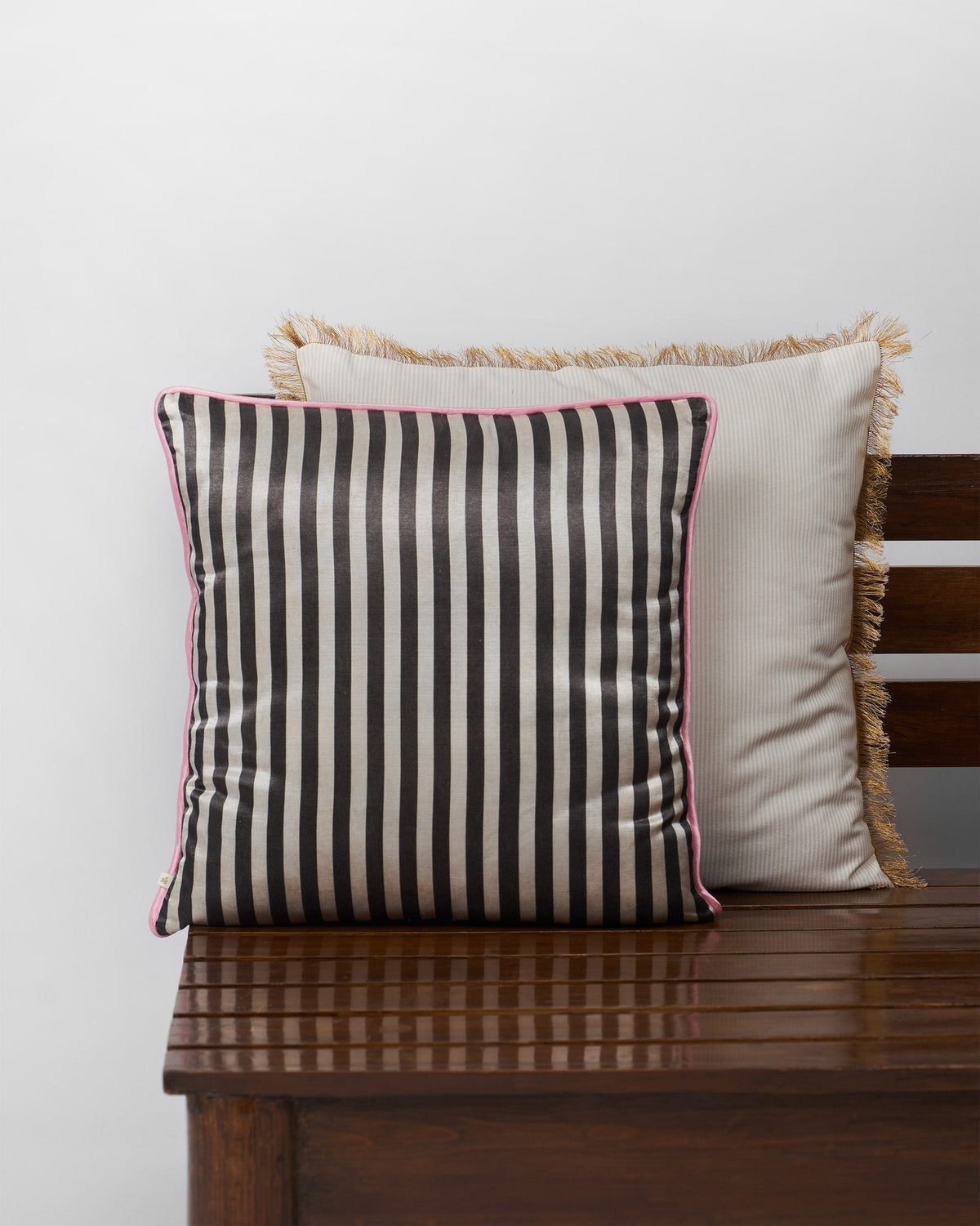 Black and cream striped cushion cover with pink piping.
