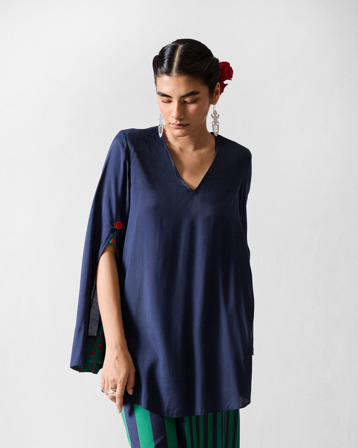 Person wearing a navy Panaji top with green floral sleeve lining.
