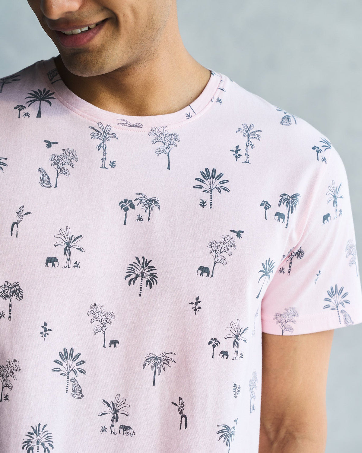 Close-up of a soft pink Jungle T-shirt showing a navy palm tree print and crew neck.