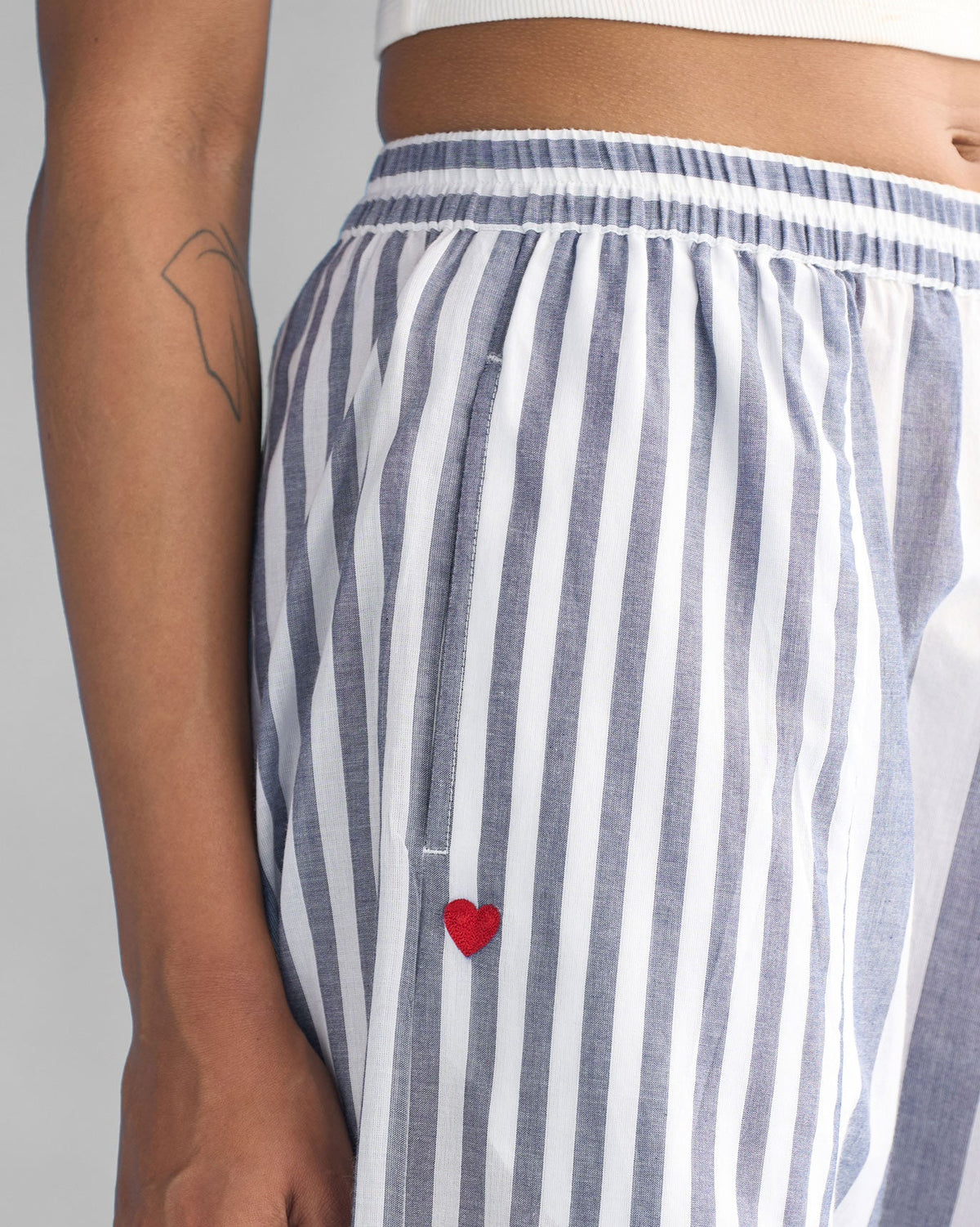Close-up of blue and white stripes on Toddy Panelled Pants with a red heart.