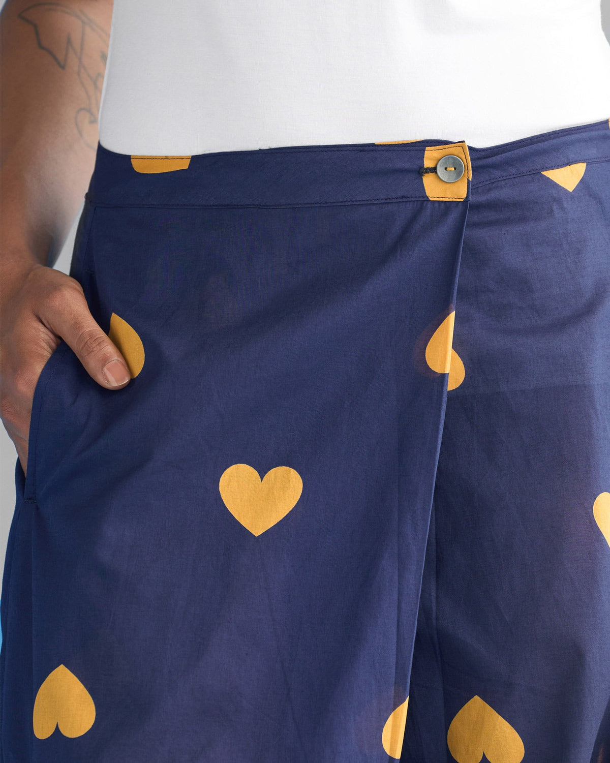 Close-up of navy Jinan Slouchy Pants showing the waist button and ochre hearts.