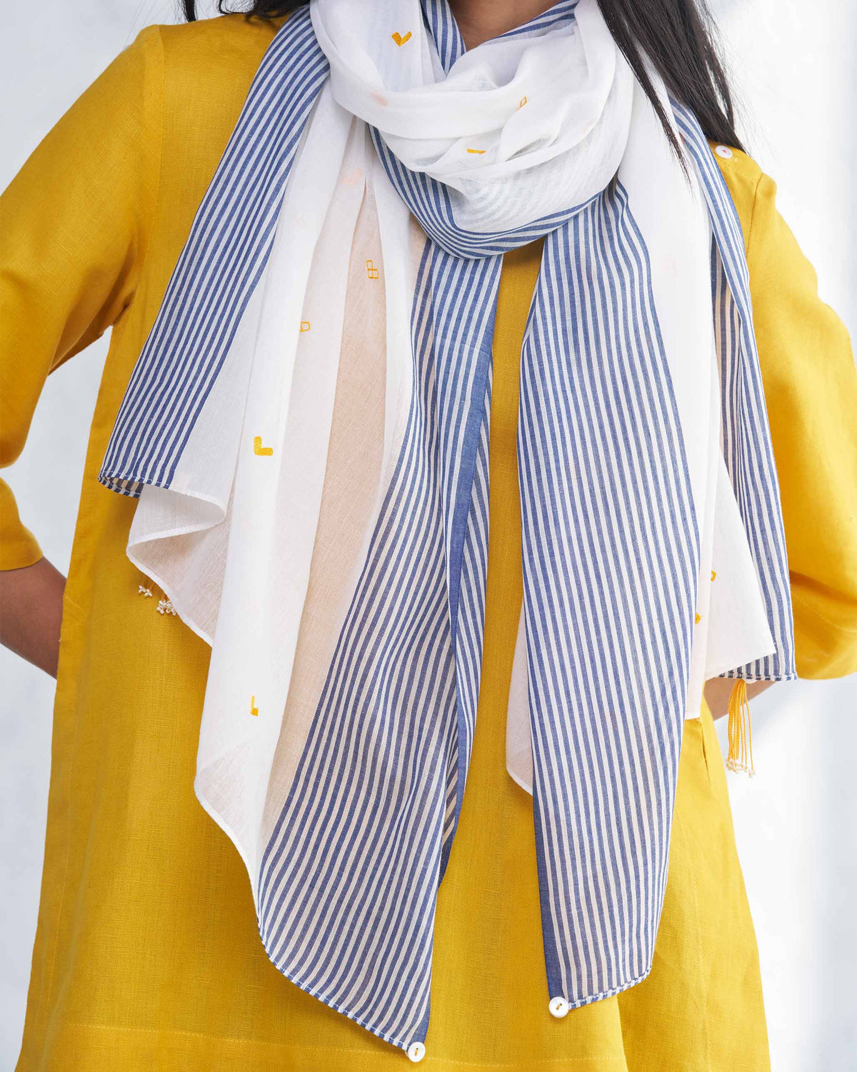 Close-up of Dokai Scarf showing its navy stripes and small yellow motifs.