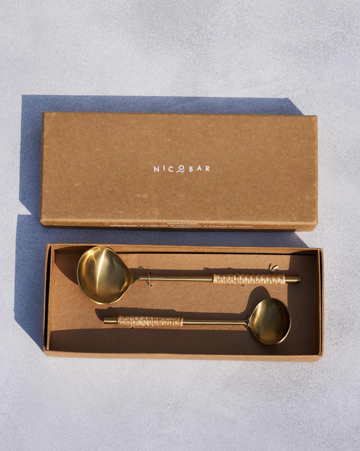 Sitara serving spoons laid in a Nicobar gift box.