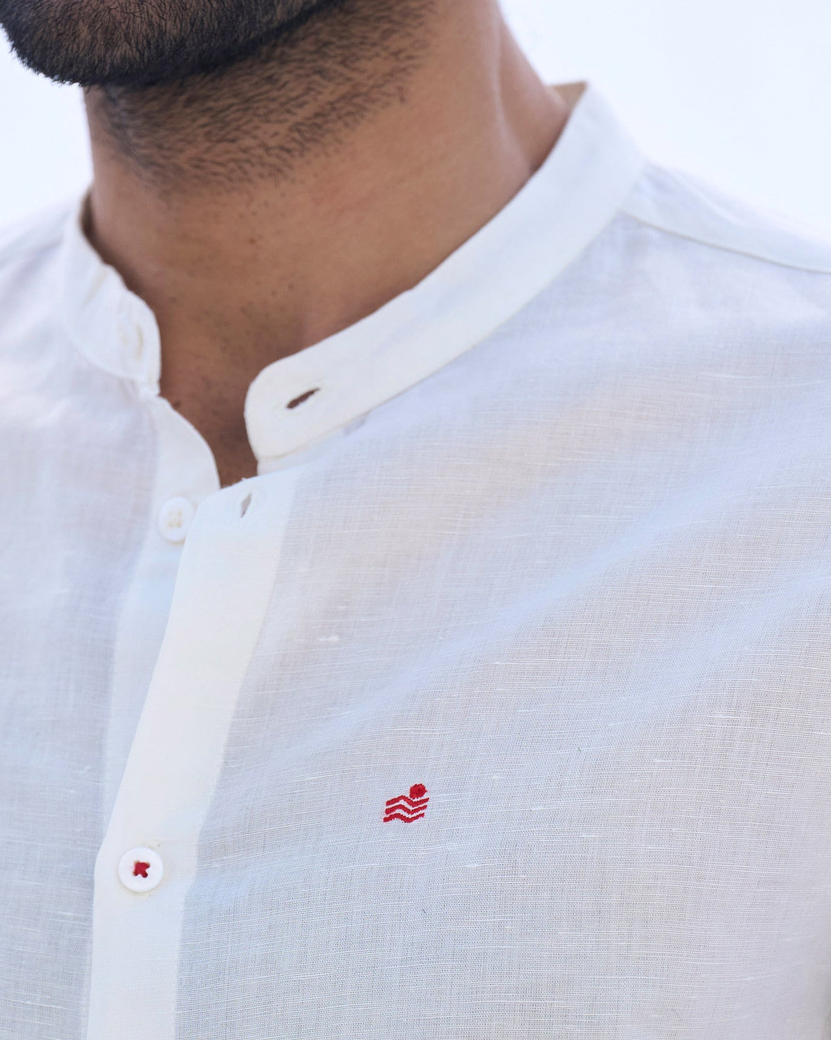 Close-up of an ivory Nawab shirt showing a small red embroidery on the chest.