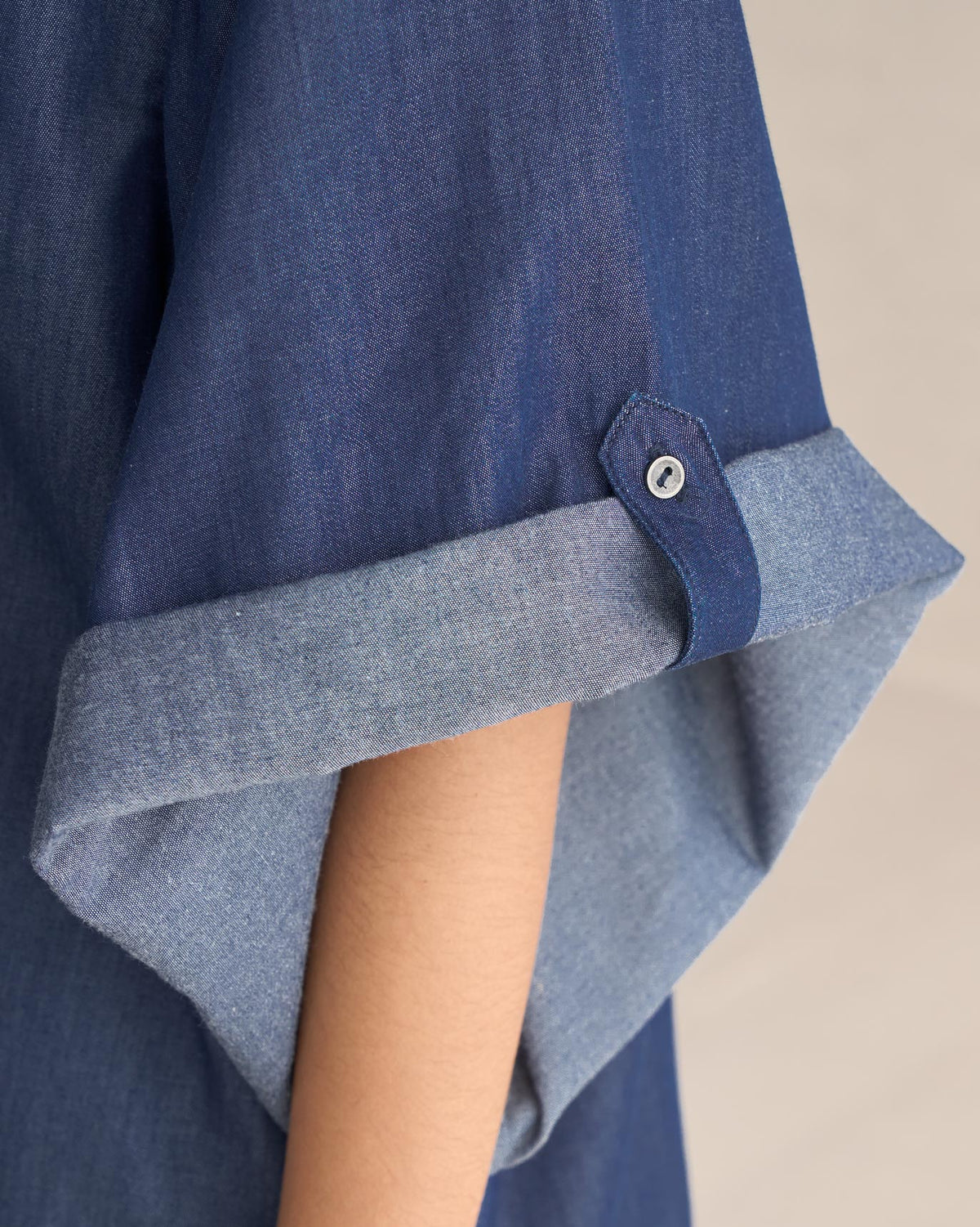 Close-up of the Drop Armhole Shirt sleeve showing a rolled cuff and button tab.