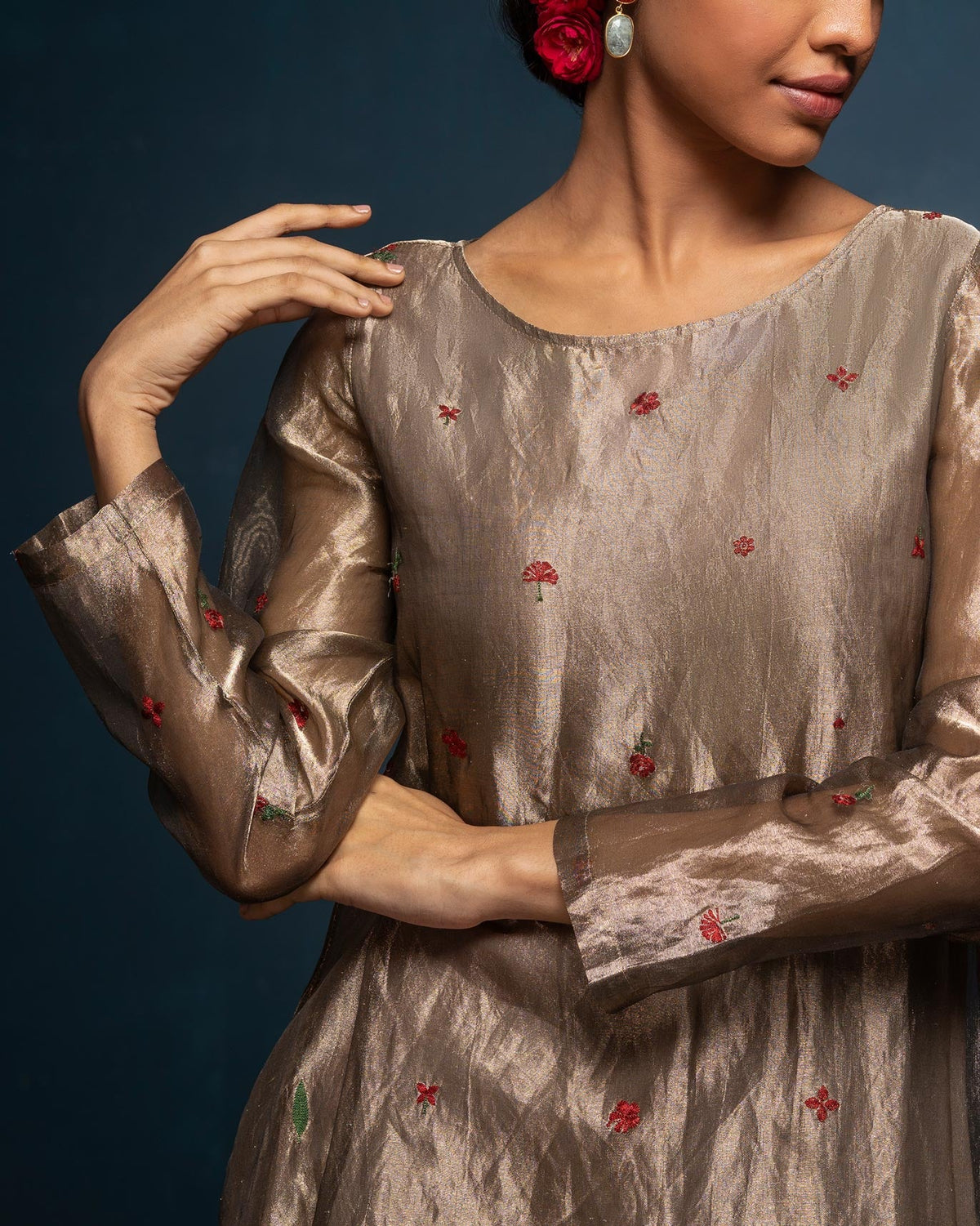 Close-up of a gold Boat Neck Kurta showing small red embroidered motifs.