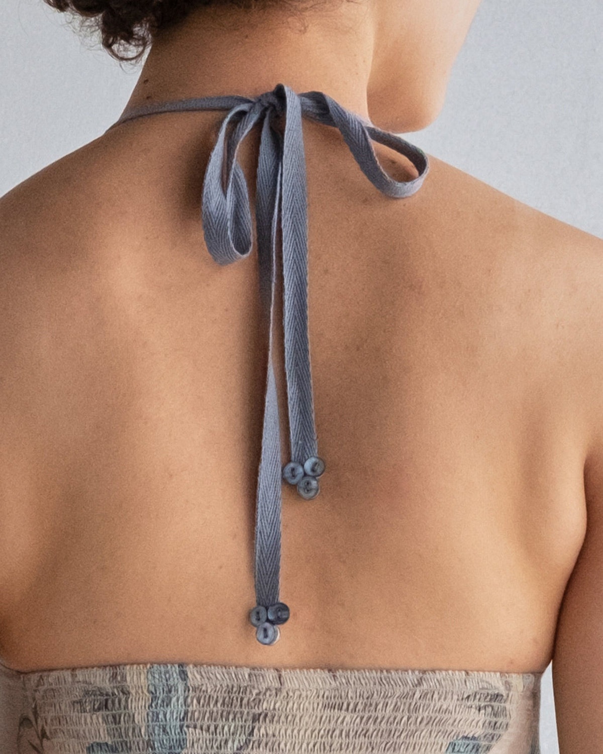 Close-up of Safar Dress halter tie in blue-grey, seen from the back.