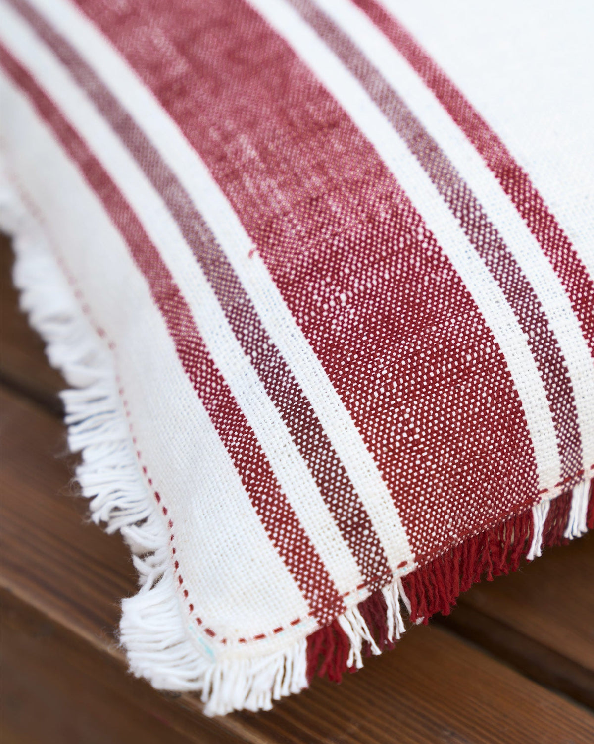 Close-up of the Cara Cushion Cover fringed edge showing red and cream stripes.
