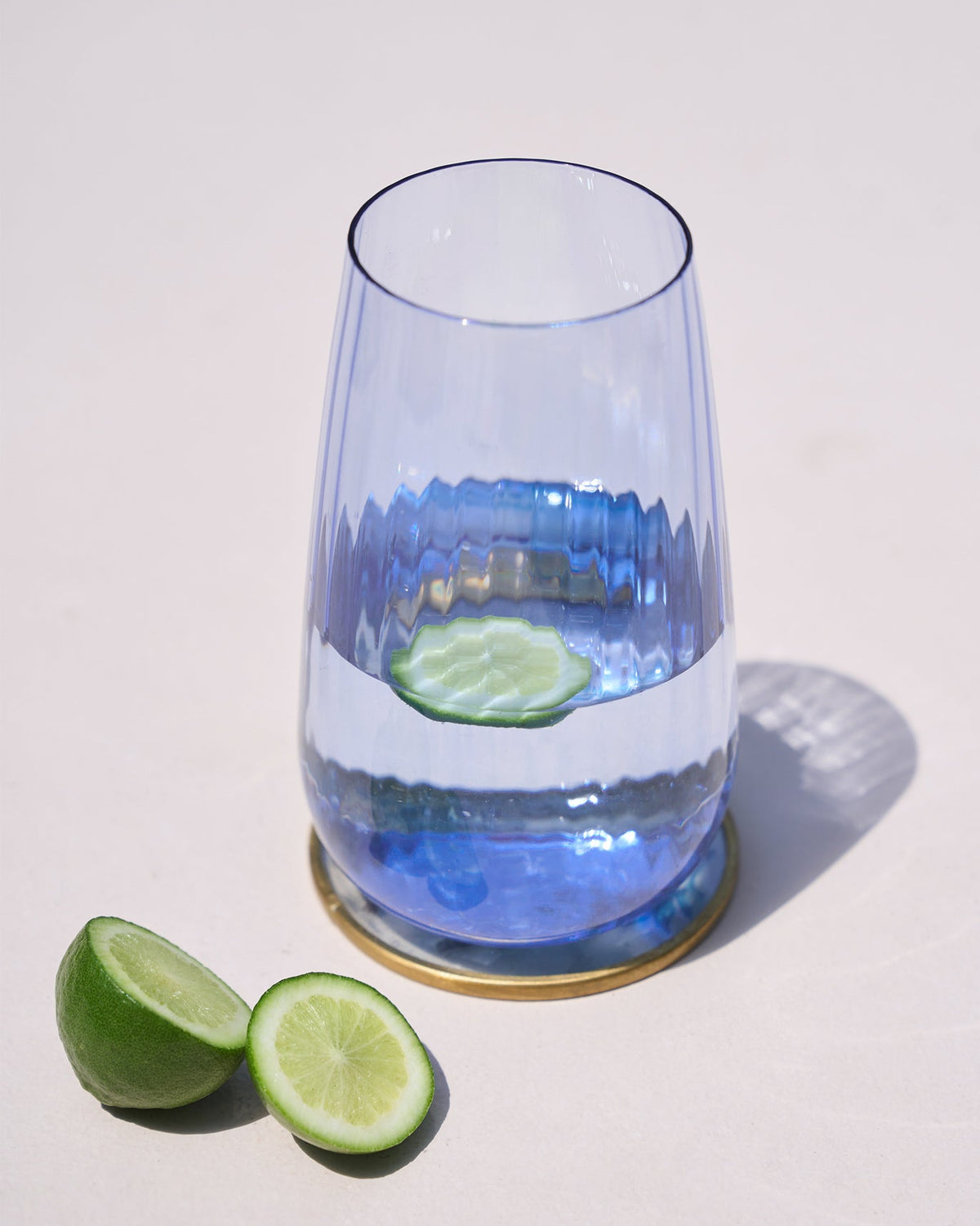 Harmony Highball Glass in blue, shown with a lime slice inside.