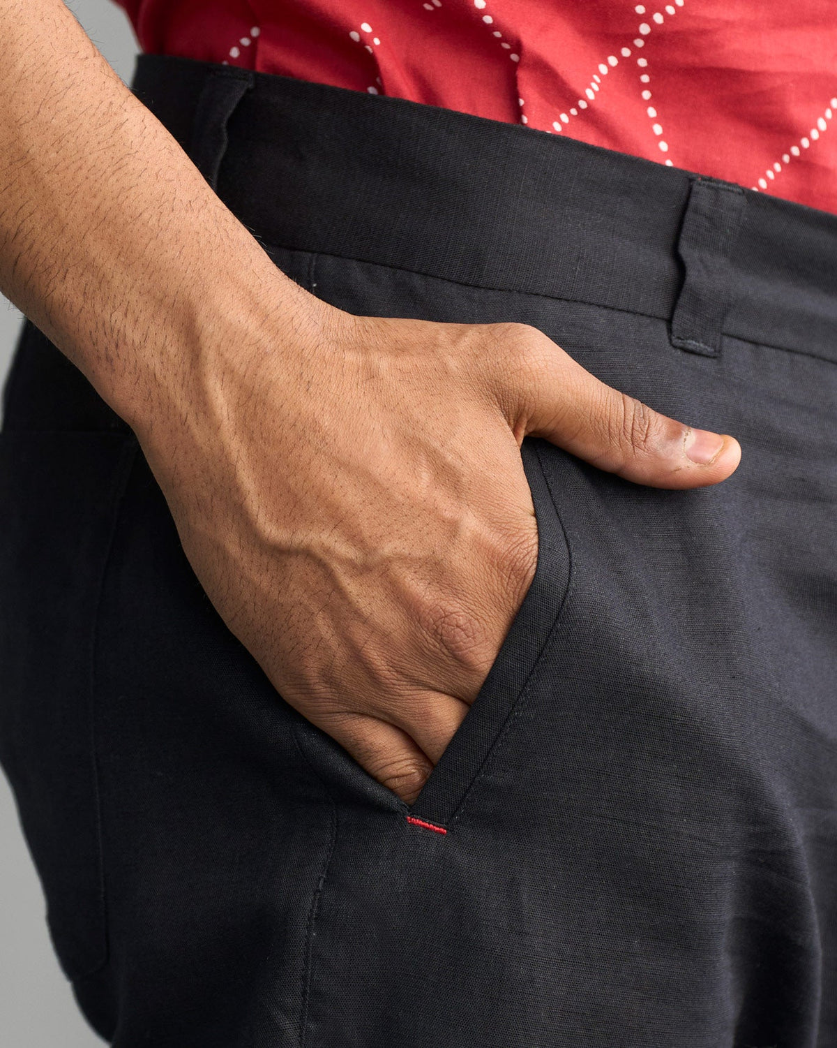 Close-up of the Comoros Trousers showing the side pocket with a red stitch.