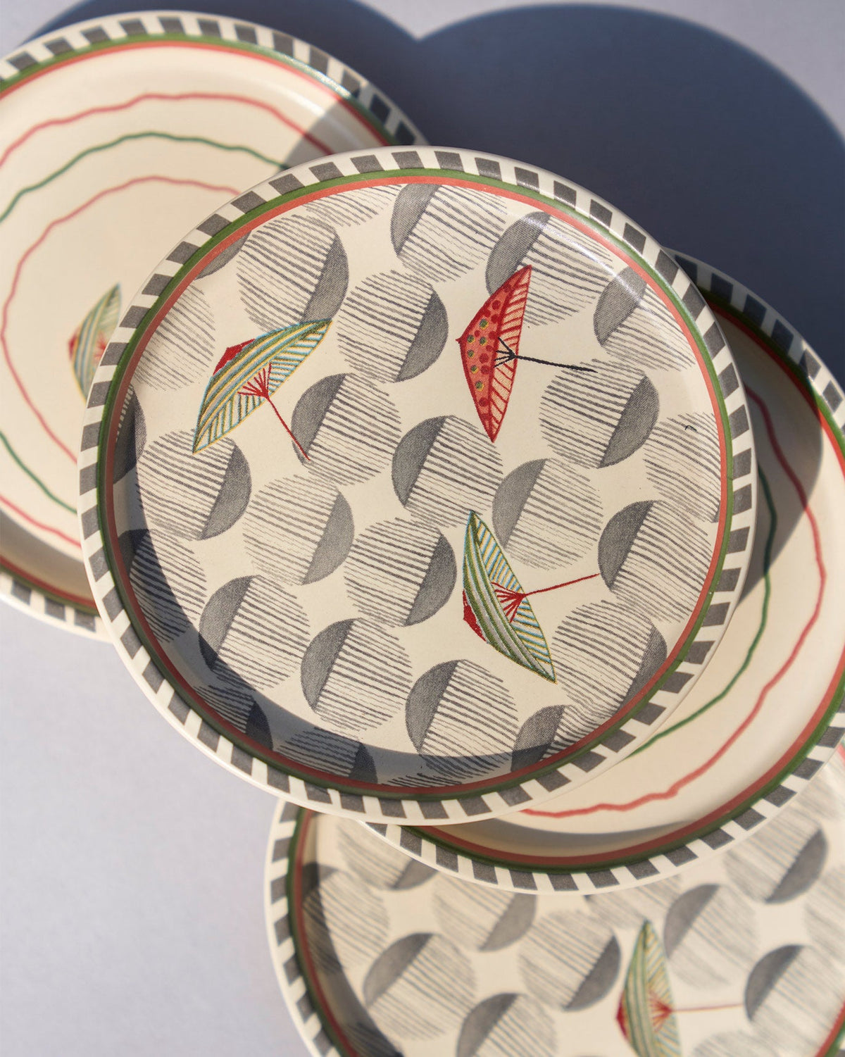 Angled view of Tribe Coasters showing red and green umbrella motifs.