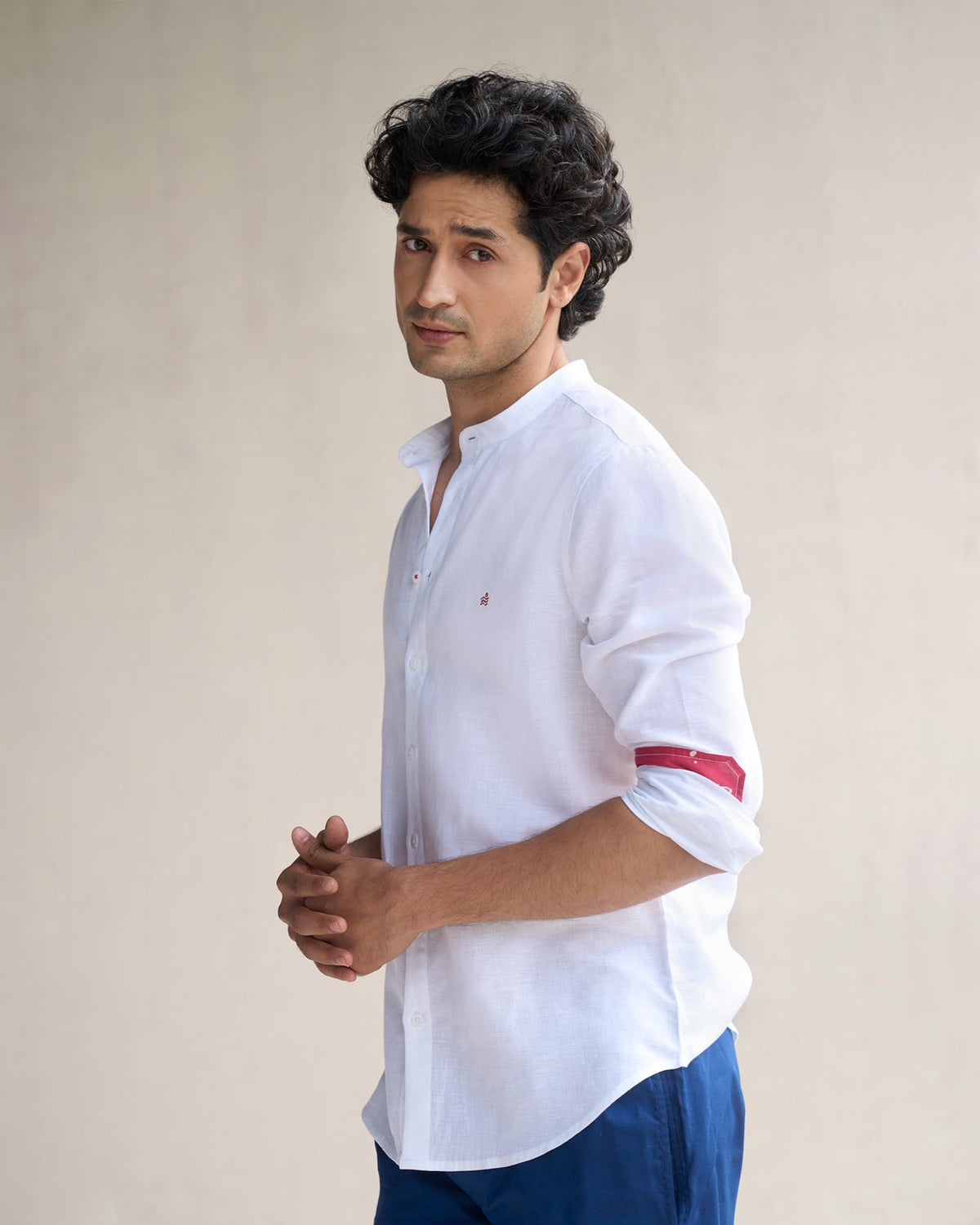 Side view of a white Nawab shirt with red cuff linings, worn by a person.