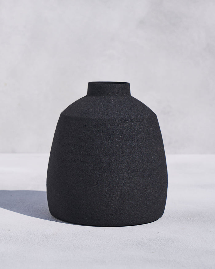 Dhaara vase in matte black with a narrow neck.