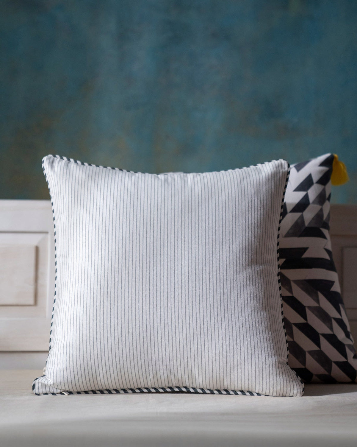Back of Winter Wonderland Cushion Cover in white pinstripe with a dark piped edge.