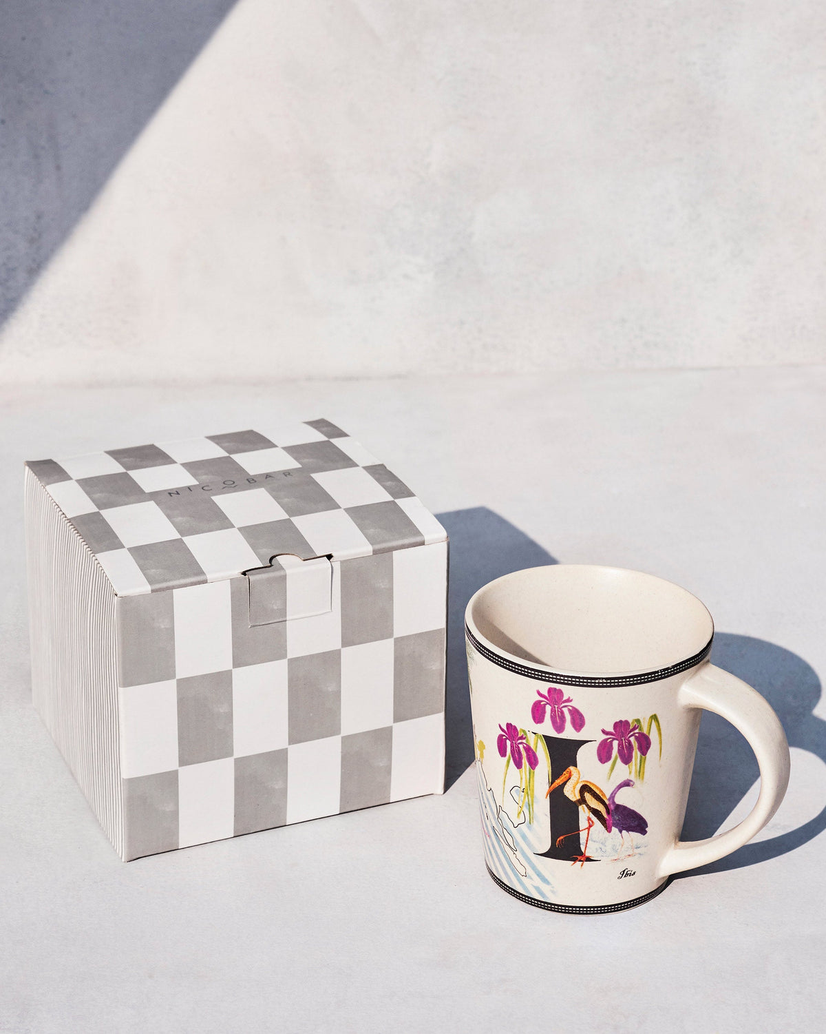 Imli mug beside a grey and white checkered gift box.
