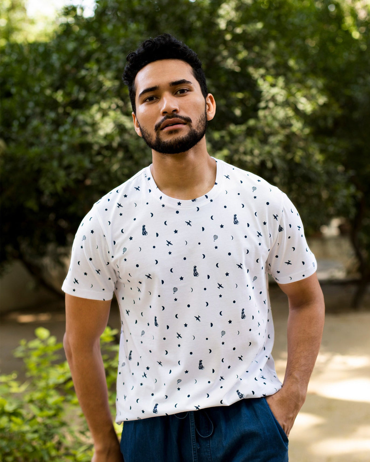 Person wearing a white Up and Away T-Shirt with a navy print of planes, moons and stars.