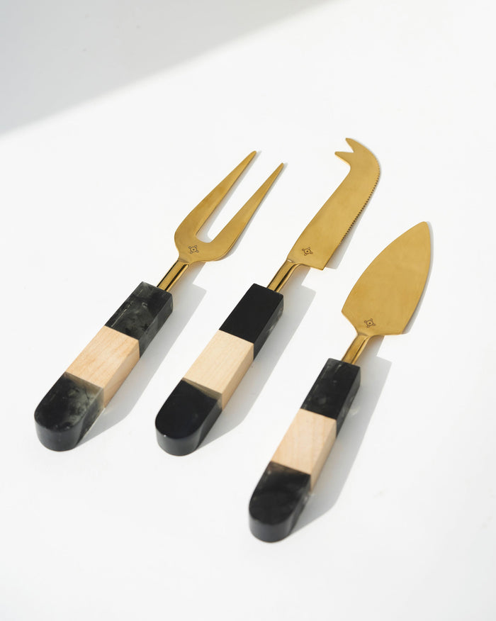 Celeste Cheese Knives (Set of 3) with gold blades and black and wood handles.