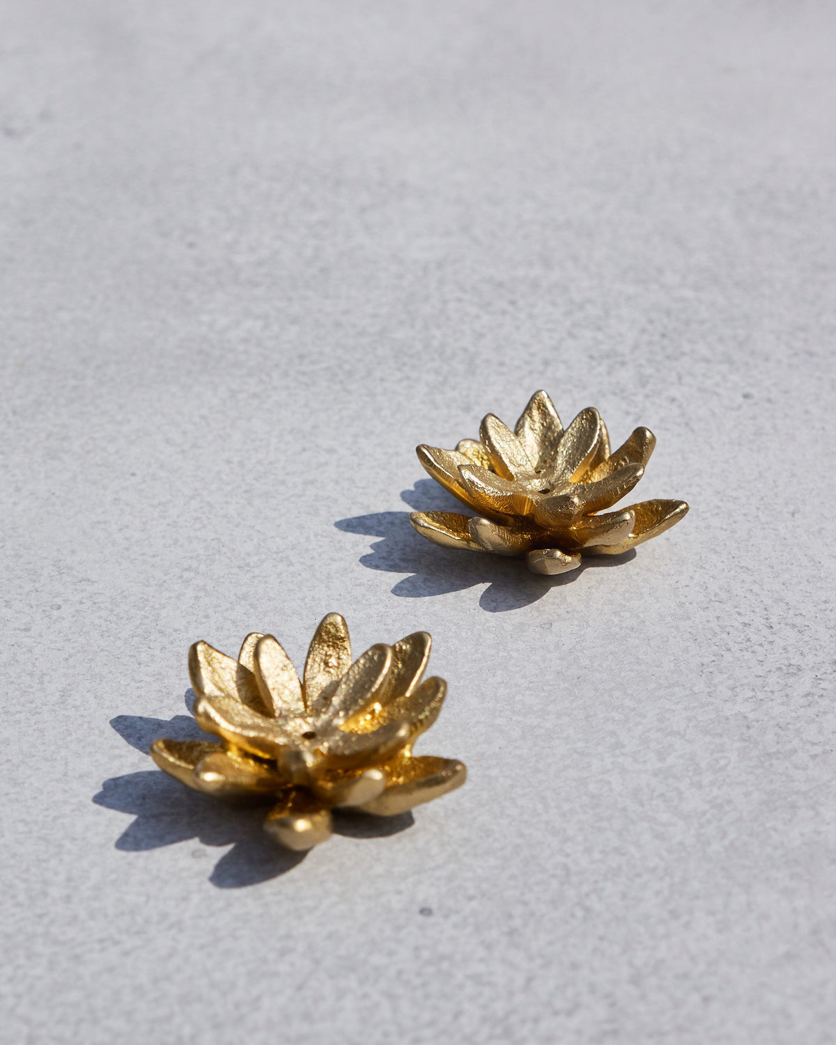 Pair of Kamal lotus incense holders in textured gold from above.