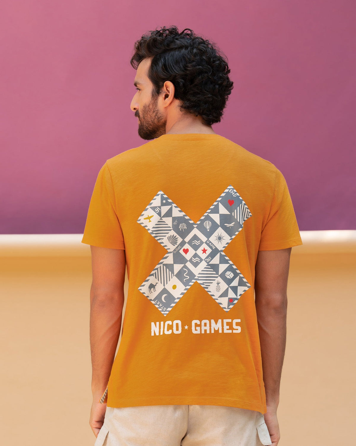 Back of an orange Roll the Dice t-shirt worn by a person.