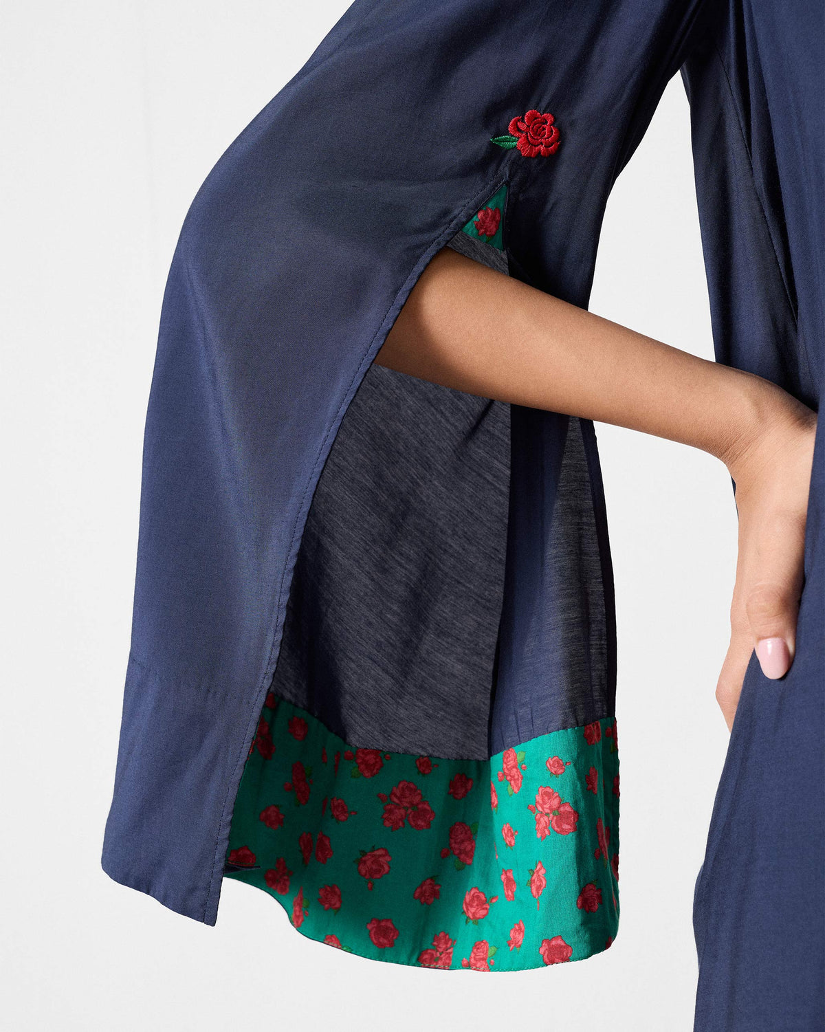 Close-up of a red rose and green floral lining on a navy Panaji sleeve.