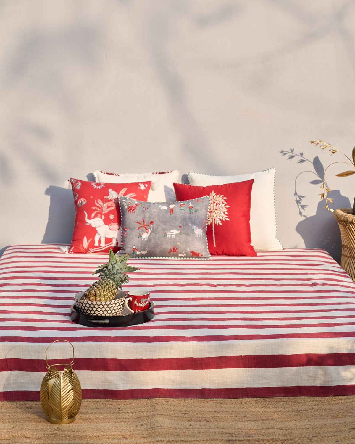 Wide view of the Bodhi Bed Cover's red and cream stripes across a bed.