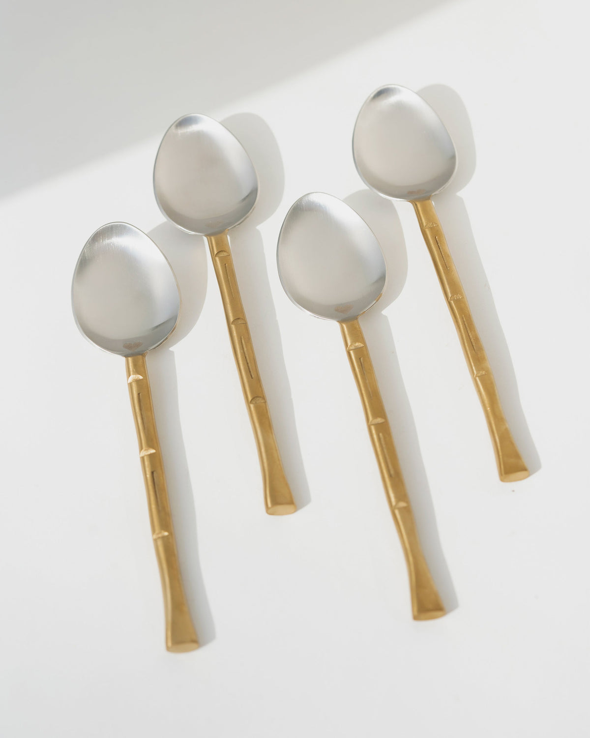 Horizon Spoon (Set of 4) with silver bowls and gold-toned segmented handles.
