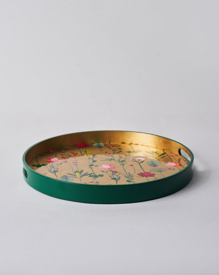 Mahi Round Tray with a green rim and a gold base printed with flowers.