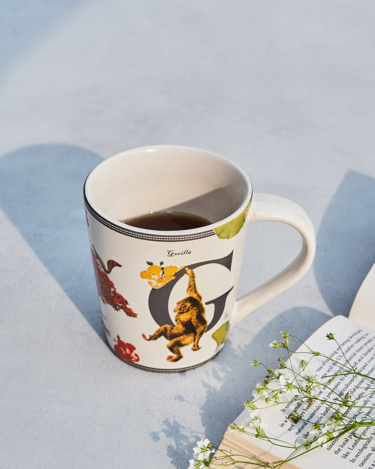 Gulmohar mug with letter G and a gorilla motif filled with a dark drink.