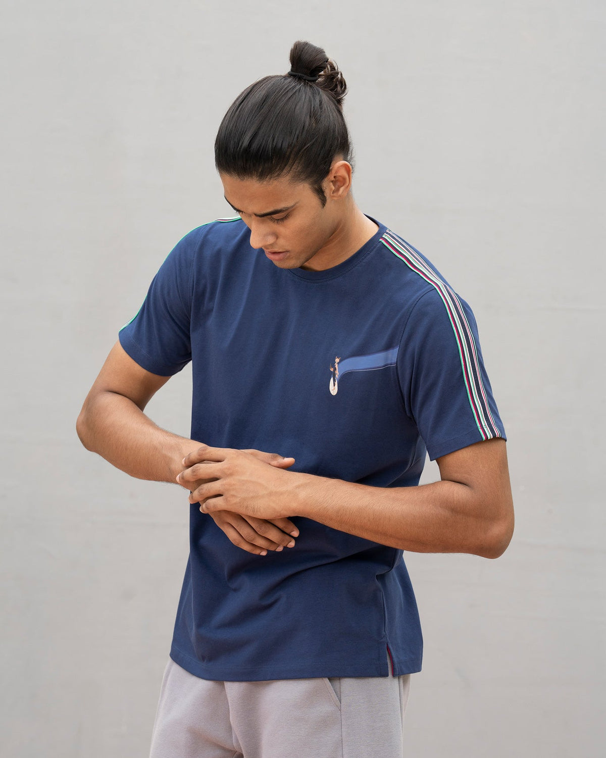 Person in a navy Nico crew neck t-shirt with a fox graphic on the chest pocket.