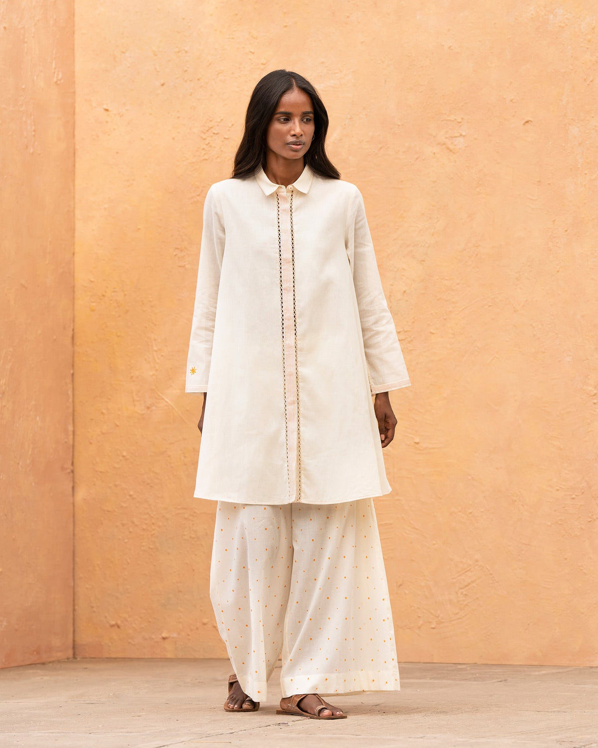 Person wearing an ivory Back Flayer Top with a collar and front placket.
