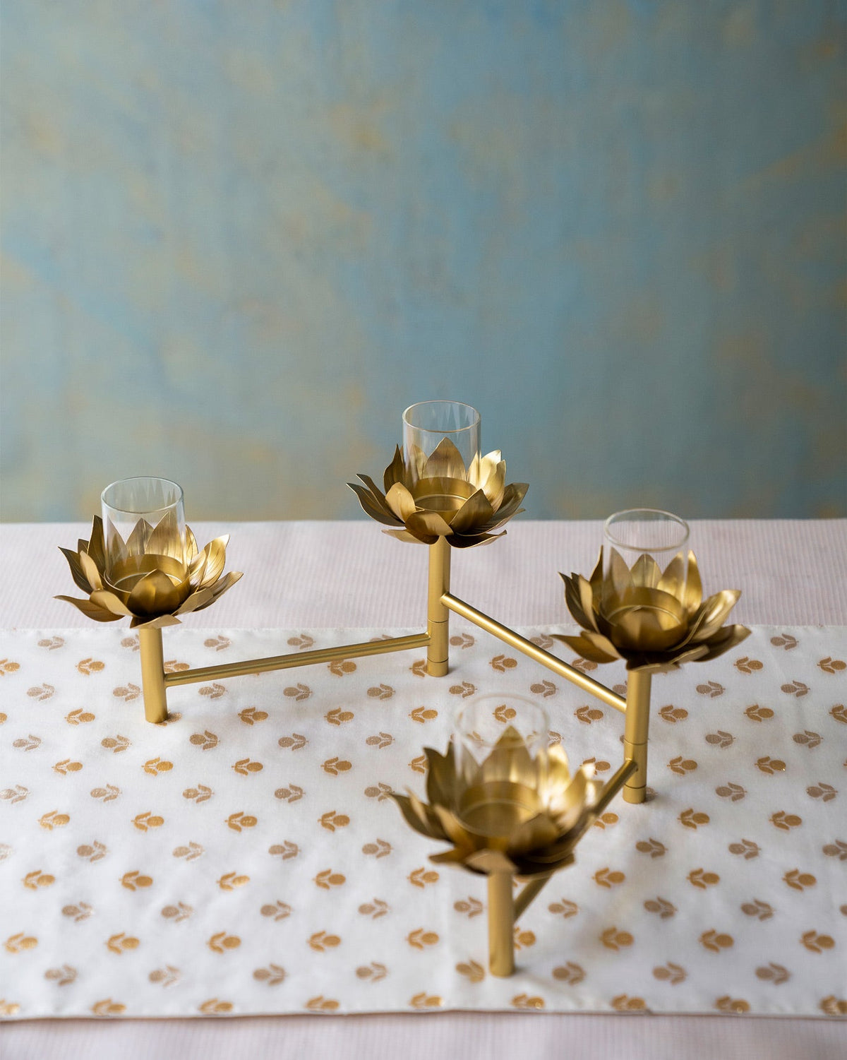 Sitara tealight stand seen at an angle, with a lit holder in the centre.