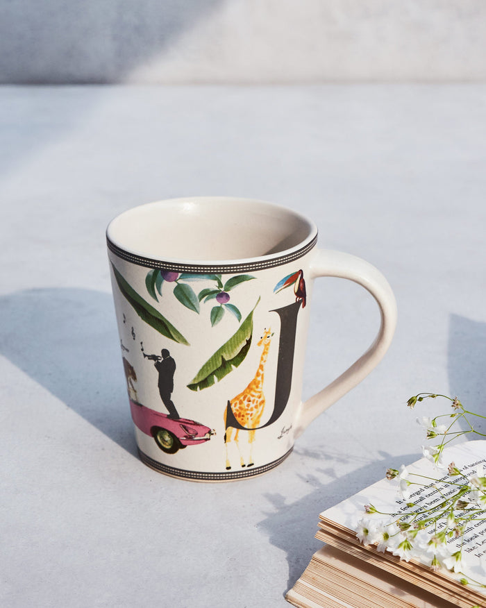Jungle mug with a giraffe, toucan and leaves printed on it.