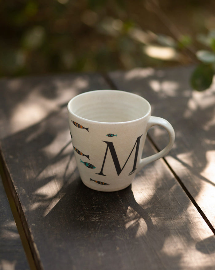 Alphabet M Mug with small fish and a large M, handle on the right.