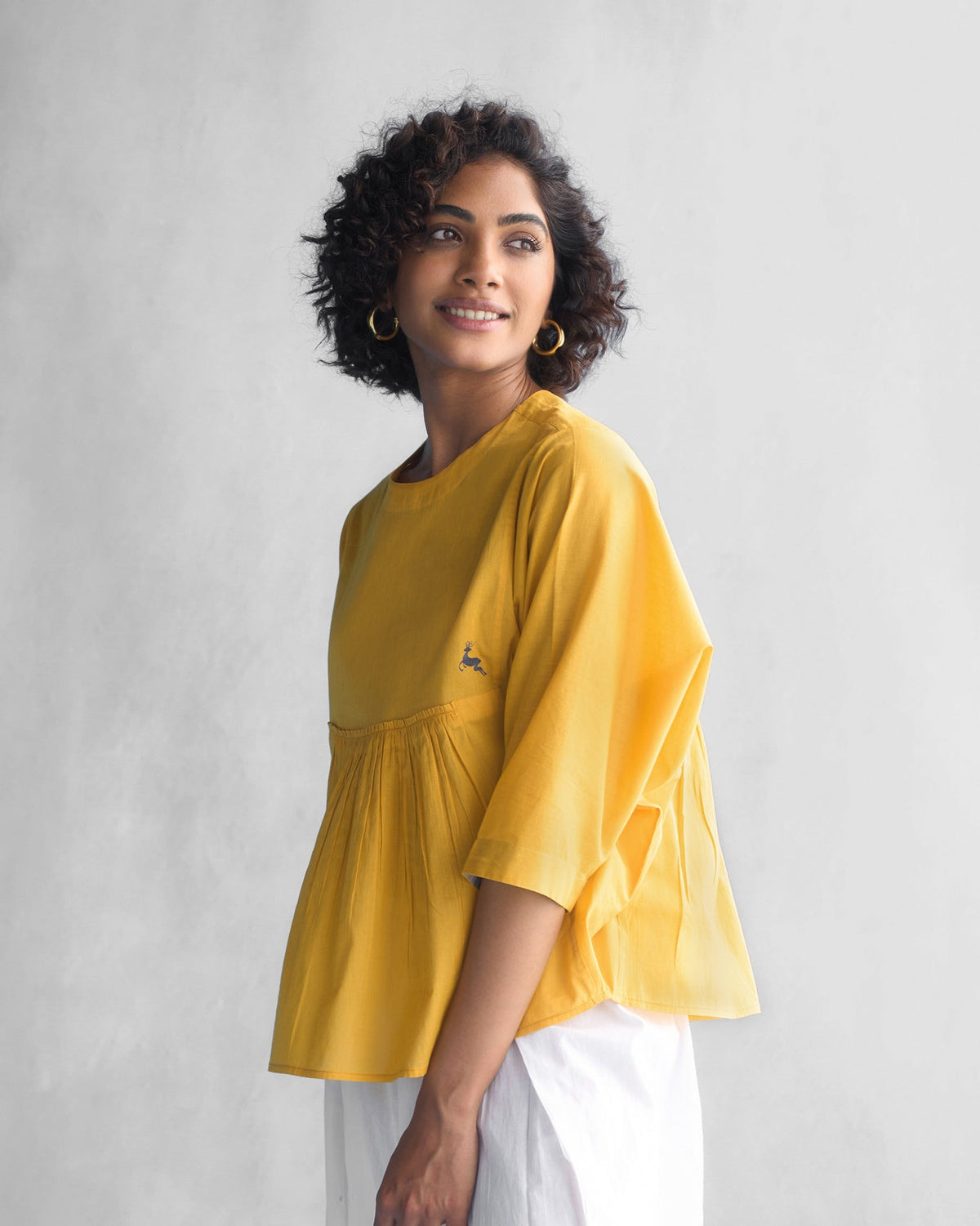 Side view of the Bougainvillea Sleeve Top in ochre with a gathered yoke.