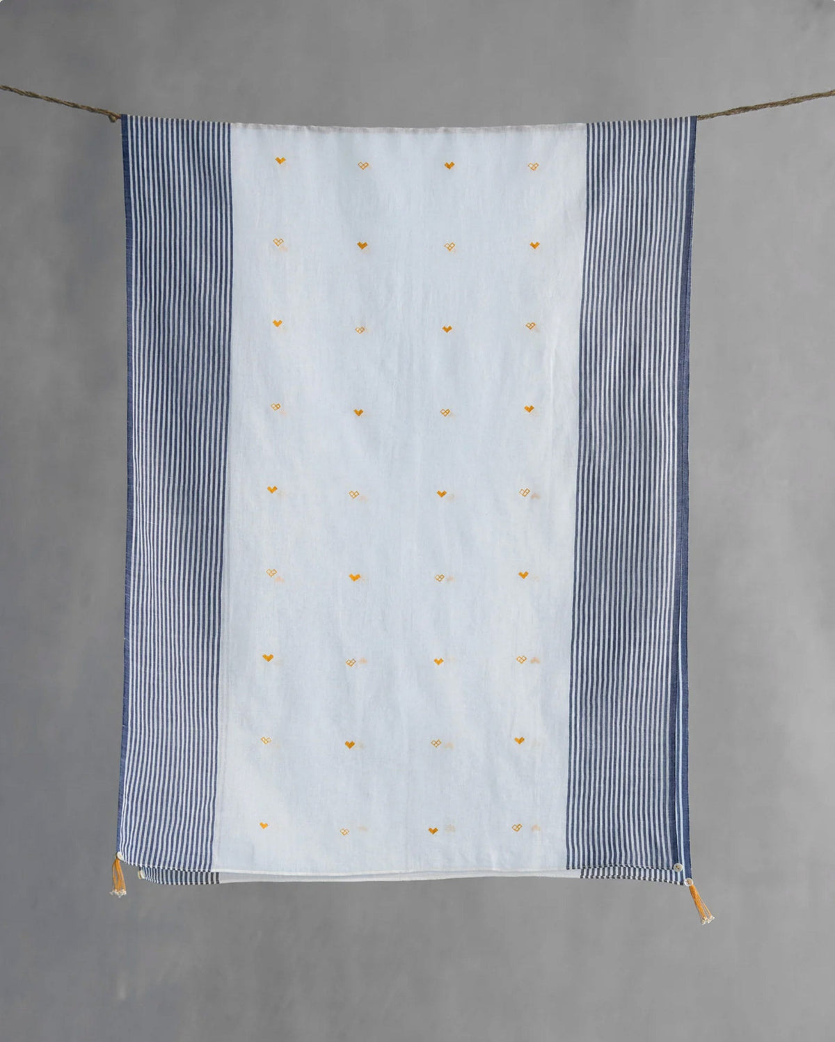 Full Dokai Scarf hung on a line showing its white field of small yellow motifs.